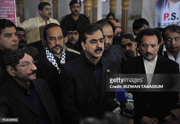 Pakistani Prime Minister Yousuf Raza Gilani talks with the media during a visit to the grave of slain former premier Benazir Bhutto on her second...