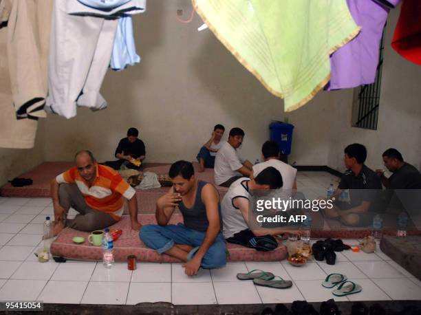 Afganistan and Iraqi men take their dinner at a detention room in Surabaya on December 27, 2009. Indonesian police said on December 27, they had...