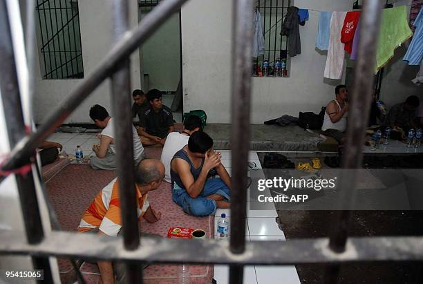 Afganistan and Iraqi men sit in a detention room in Surabaya on December 27, 2009. Indonesian police said on December 27, they had detained in East...