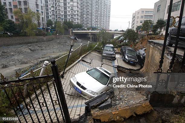 Trapped sedans are seen in a cave-in of a road at the Jinri Jiayuan Residential Community on December 27, 2009 in Wenzhou of Zhejiang Province,...