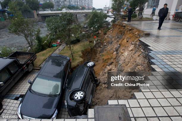 Trapped sedans are seen in a cave-in of a road at the Jinri Jiayuan Residential Community on December 27, 2009 in Wenzhou of Zhejiang Province,...