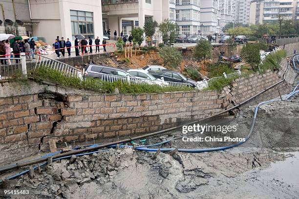 Trapped sedans are seen in a cave-in of a road at the Jinri Jiayuan Residential Community on December 27, 2009 in Wenzhou of Zhejiang Province,...