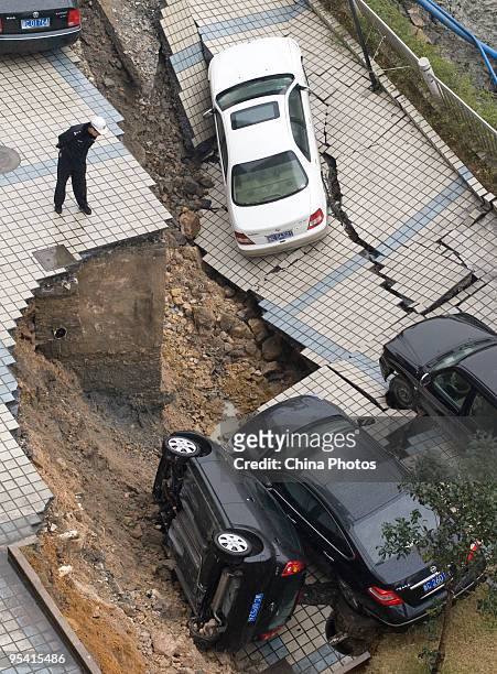 Trapped sedans are seen in a cave-in of a road at the Jinri Jiayuan Residential Community on December 27, 2009 in Wenzhou of Zhejiang Province,...