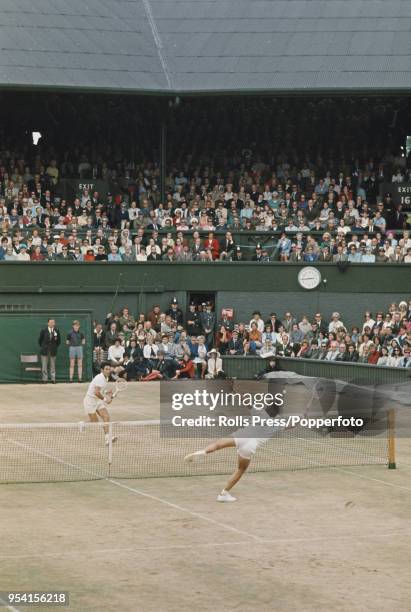 View of action between Australian tennis players John Newcombe and Ken Rosewall in the final of the Men's singles tournament at the Wimbledon Lawn...