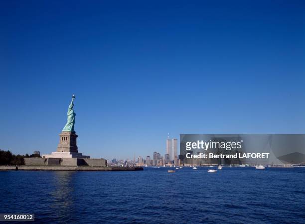 La statue de la Liberté face à Manhattan et à l'arrière-plan les tours jumelles du World Trade Center, circa 1980, à New York, Etats-Unis.