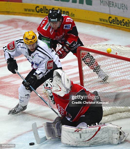 Tobias Woerle of Frankfurt Lions shoots the puck and Lars Weibel of the Haie saves the puck during the DEL match between Koelner Haie and Frankfurt...