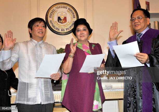 Supreme Court Associate Justice Diosdado Peralta admisters the oath of office on ex-Philippine first lady Imelda Marcos and her son, Ferdinand Marcos...