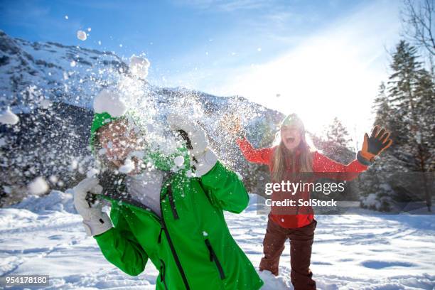 lucha de bolas de nieve en unas vacaciones de esquí - lucho en familia fotografías e imágenes de stock