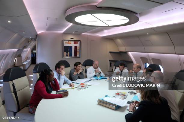 French President Emmanuel Macron takes part in a meeting in his presidential plane Airbus A330 with his advisors Sibeth Ndiaye , Marie Argouarche and...