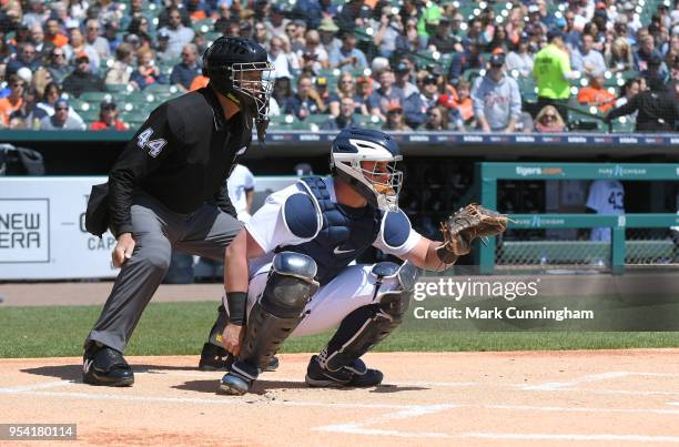 Catcher James McCann of the Detroit Tigers and Major League umpire Kerwin Danley crouch behind home plate during the game against the Kansas City...