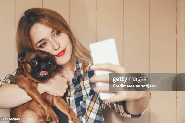 woman and her dog taking a selfie with smartphone - griffon bruxellois stock pictures, royalty-free photos & images