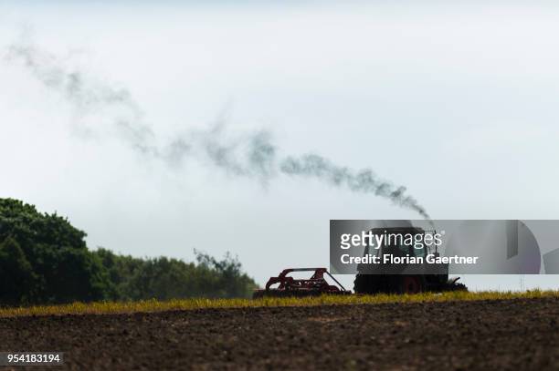 Tractor emits exhaust gas on a field on April 30, 2018 in Hilbersdorf, Germany.
