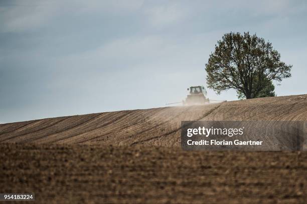Tractor with a drill seed is pictured on a field on April 30, 2018 in Koenigshain, Germany.