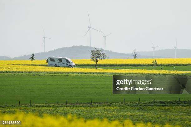 Caravan drives along a street between fields of rape on April 30, 2018 in Schoepstal, Germany.