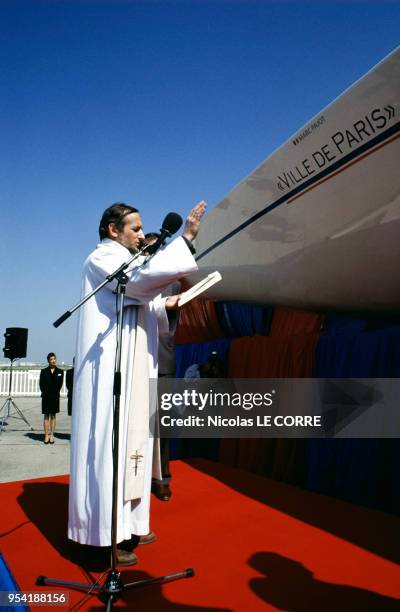 Le père Le Roy bénit le bateau de Marc Pajot, en France le 10 avril 1991.