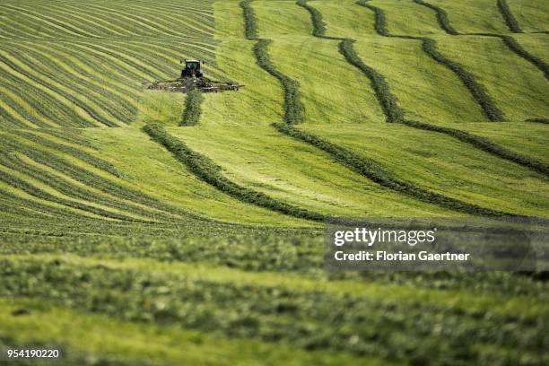 Tractor with a windrow is pictured on a field on May 01, 2018 in Schoenau-Berzdorf, Germany.