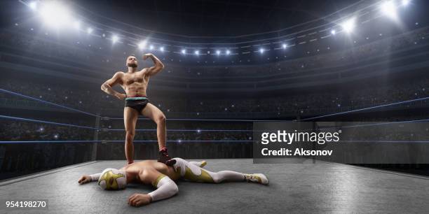 wrestling-show. zwei wrestler in einem hellen sportkleidung und gesichtsmaske im ring kämpfen - ringen stock-fotos und bilder