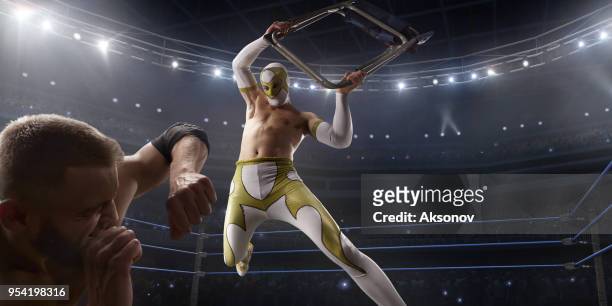 摔跤表演兩個摔跤運動員在一個明亮的運動服裝和口罩戰鬥在環 - 技擊運動 個照片及圖片檔