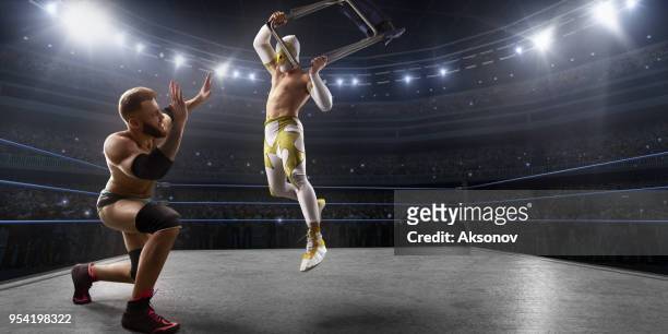 wrestling show. two wrestlers in a bright sport clothes and face mask fight in the ring - wrestling ring stock pictures, royalty-free photos & images