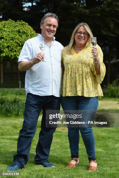 Sue Richards, 51 and 58-year-old Barry Maddox who have cut a design of a giant champagne bottle and glasses in to their lawn, at their home in...