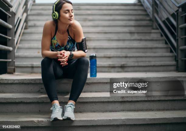 mujer joven de estiramiento antes del ejercicio - una sola mujer joven fotografías e imágenes de stock