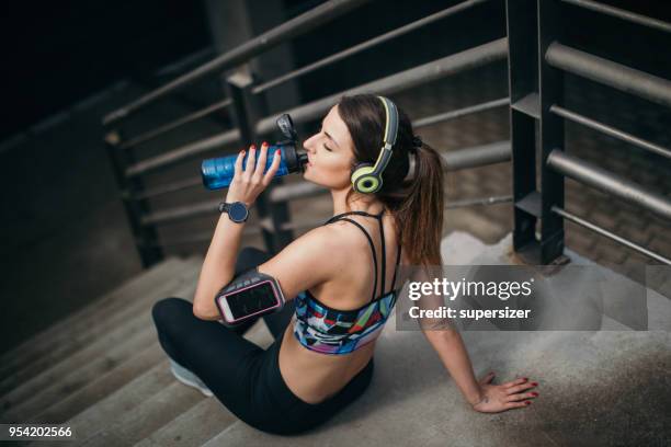 young woman stretching before exercise - high contrast athlete stock pictures, royalty-free photos & images