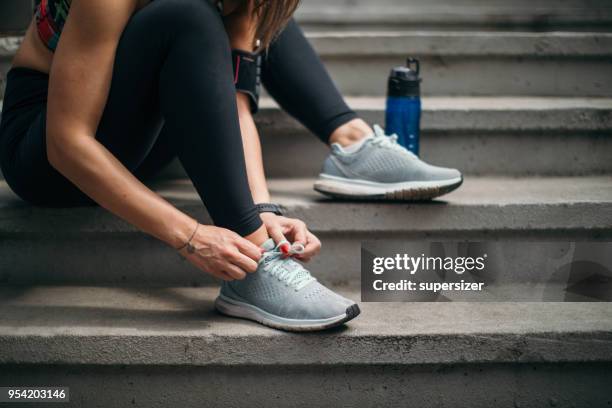 mujer joven de estiramiento antes del ejercicio - una sola mujer joven fotografías e imágenes de stock