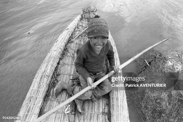 Un jeune enfant en pirogue sur lac Titicaca après de graves inondations en mars 1986, Puno, Pérou.