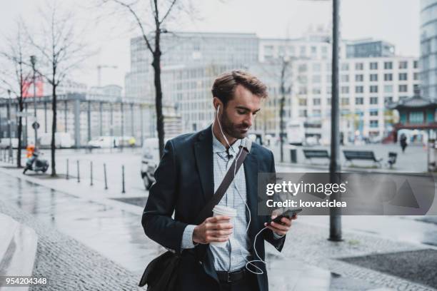 Unternehmer, die auf der Straße Musik hören und mit Smartphone