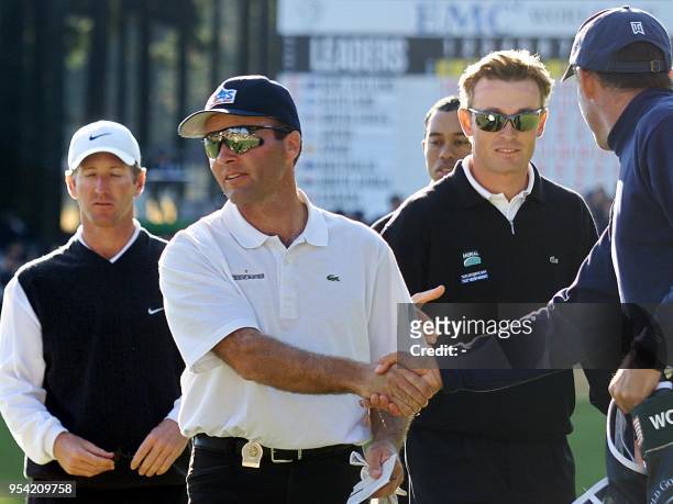 French golfer Thomas Levet shakes hands with Tiger Woods' caddie, Steve Williams while his teammate, Raphael Jacquelin of France , US team members,...