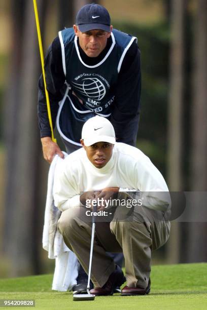 American team golfer, Tiger Woods checks a putting line with his caddie, Steve Williams on the 13th green during the third day competition of the...