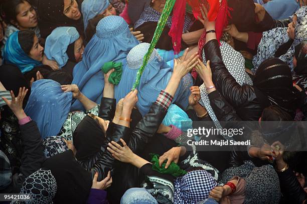 Afghan women reach to touch Shiite religious flags during Ashura in Kabul, Afghanistan on December 27, 2009. Ashura is a 10 day period of mourning...