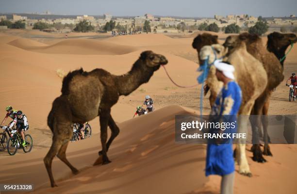 Competitors ride their bikes during Stage 5 of the 13th edition of Titan Desert 2018 mountain biking race around Merzouga in Morocco on May 3, 2018....