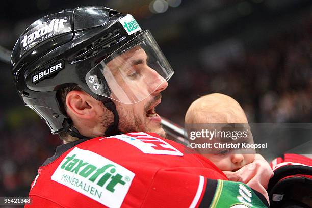 Ivan Ciernik celebrates the 4-1 victory with his baby after the DEL match between Koelner Haie and Frankfurt Lions at the Lanxess Arena on December...