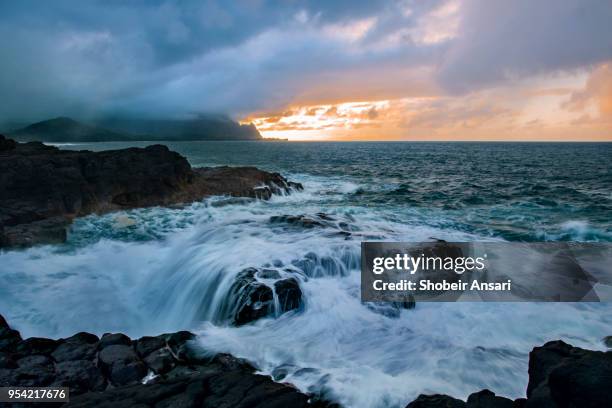 wave action before sunset in princeville shore, kauai, hawaii - princeville stock pictures, royalty-free photos & images