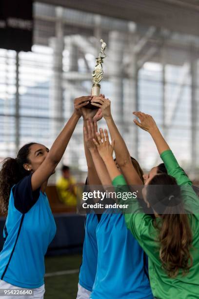 beautiful latin american soccer players celebrating they won holding the trophy up high - sports team win stock pictures, royalty-free photos & images