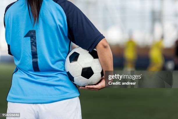 unrecognizable female soccer player showing the back of her shirt and holding the soccer ball - soccer shirt stock pictures, royalty-free photos & images