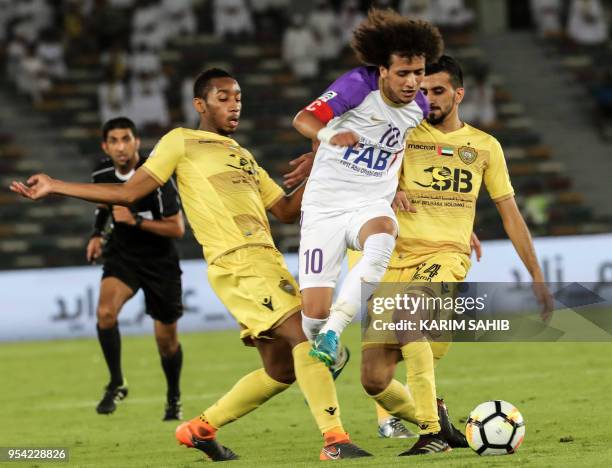 Al-Wasl's Emirati midfielders Hamad Mohammad Ibrahim and Ali Hassan vie against Al-Ain's Emirati midfielder Omar Abdulrahman during the United Arab...