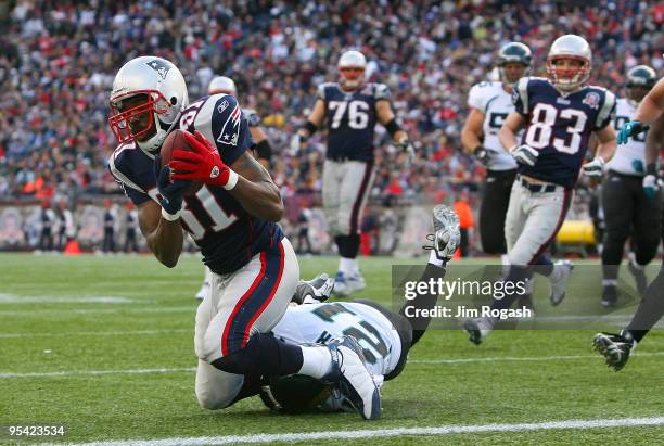 Randy Moss of the New England Patriots catches his third touchdown pass of the day against the defense of Derek Cox Jaguars in the fourth quarter at...