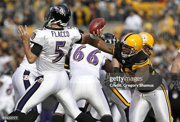 LaMarr Woodley of the Pittsburgh Steelers disrupts the throwing arm of Joe Flacco of the Baltimore Ravens on December 27, 2009 at Heinz Field in...