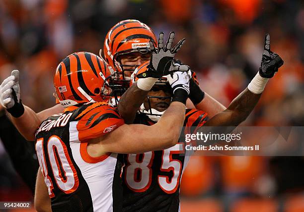 Chad Ochocinco of the Cincinnati Bengals celebrates his touchdown catch by holding up the number 15 in memory of teammate Chris Henry with Brian...