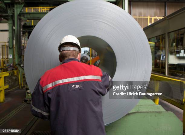 Steel production at ThyssenKrupp in Duisburg. The picture shows a worker at a finished produced steel roll in a storage hall for cold-rolled sheet.