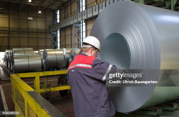 Steel production at ThyssenKrupp in Duisburg. The picture shows a worker at a finished produced steel roll in a storage hall for cold-rolled sheet.