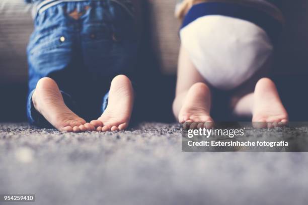 photograph of the feet of two twin brothers playing together - daycare stock pictures, royalty-free photos & images