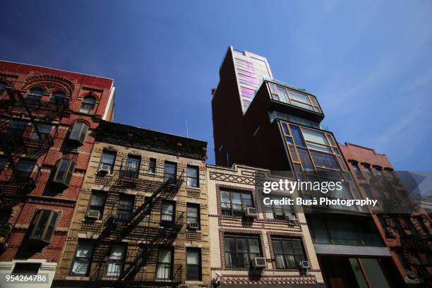 mix of old walkups and new luxury condominium building in orchard street in the lower east side, manhattan, new york city, usa - gentrification stock-fotos und bilder