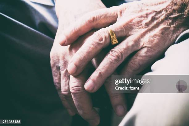 senior man sitting on chair with his hands on knees - interlocking fingers stock pictures, royalty-free photos & images