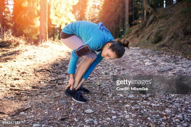 young sporty woman massaging her ankle - twisted ankle stock pictures, royalty-free photos & images