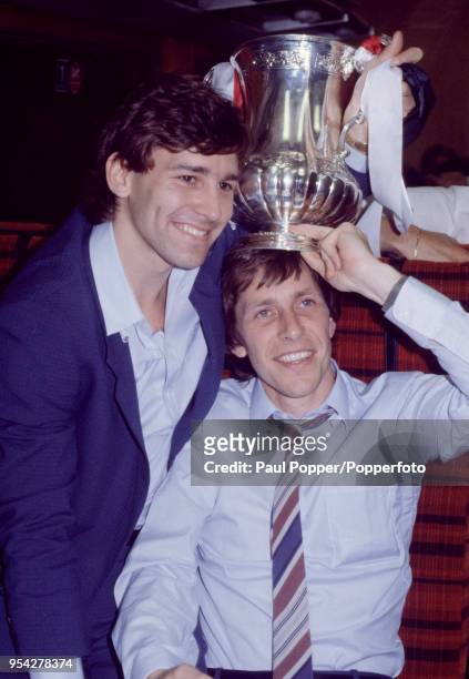 Bryan Robson and Arnold Mühren of Manchester United celebrate with the trophy on the train journey home after the FA Cup Final Replay between...