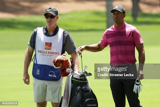 Tiger Woods pulls an iron from his bag prior to his shot on the second hole during the first round of the 2018 Wells Fargo Championship at Quail...