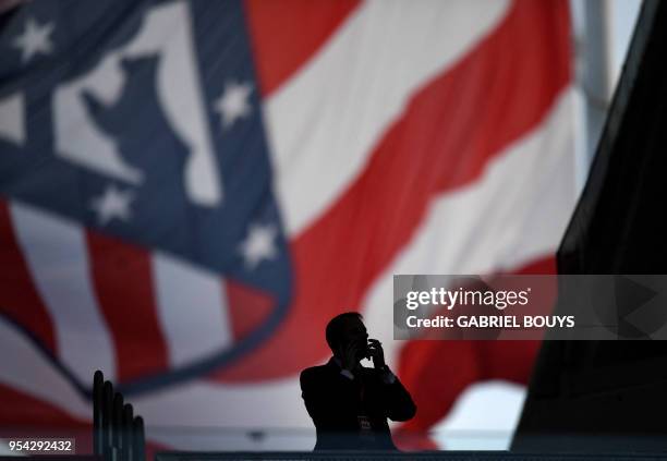 Man smokes as he waits for the start of the game while a big Atletico Madrid flag flies on the background before the UEFA Europa League semi-final...